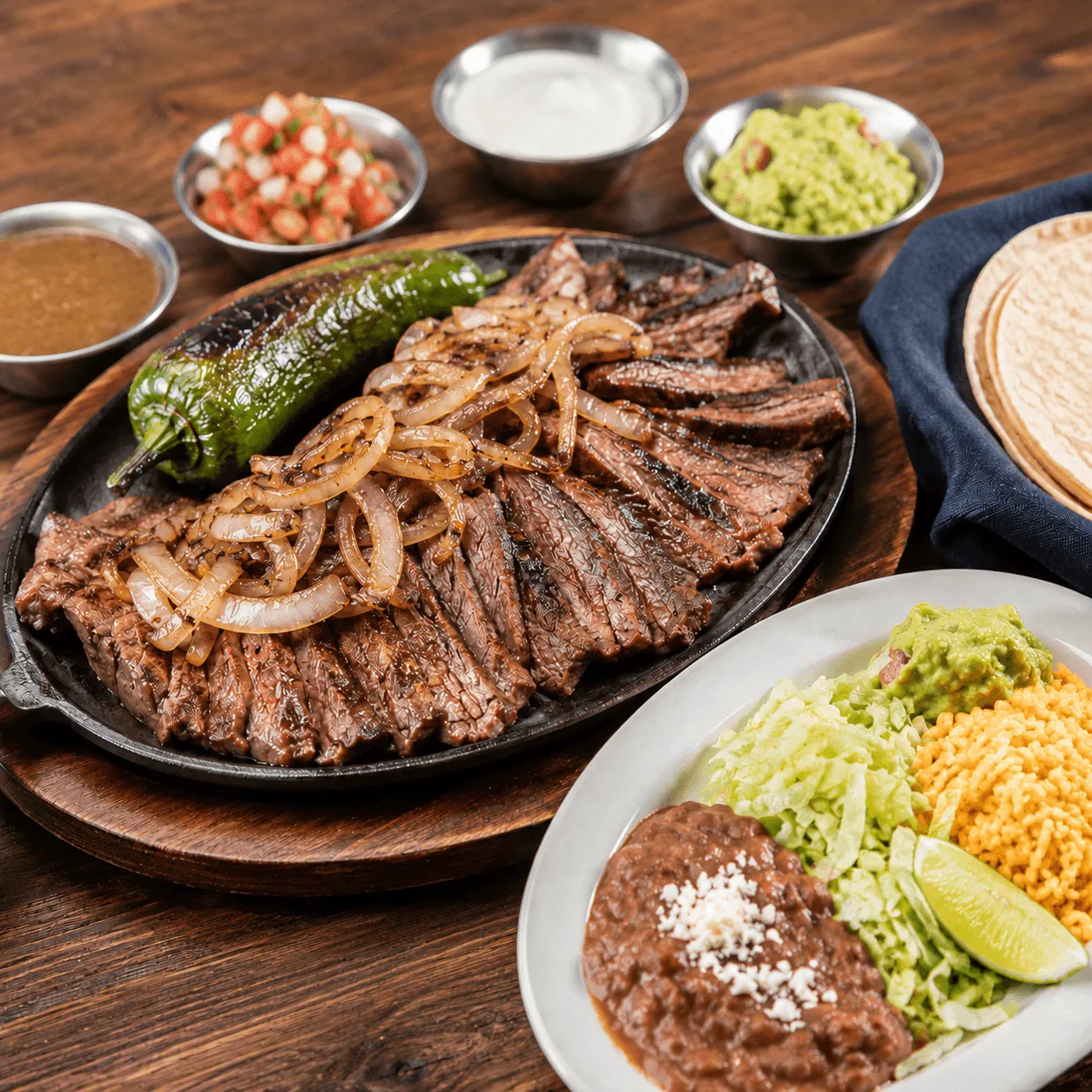 Carne Asada with grilled sliced steak, rice, beans, guacamole and tortillas