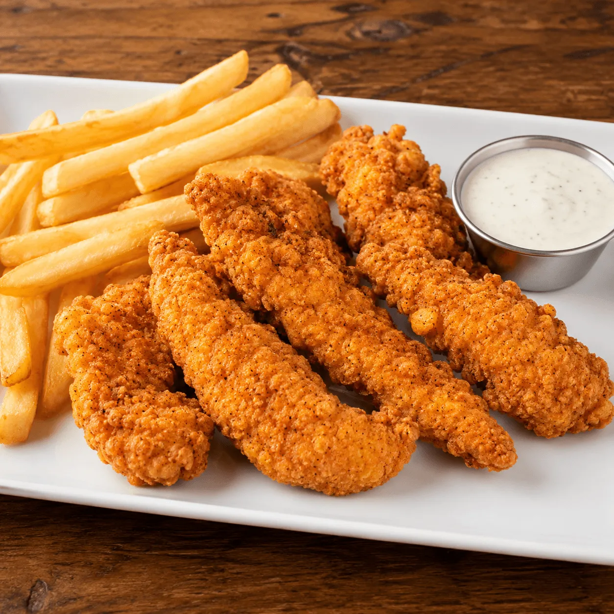 Five crispy homemade Chicken Tenders with French fries and ranch dipping sauce