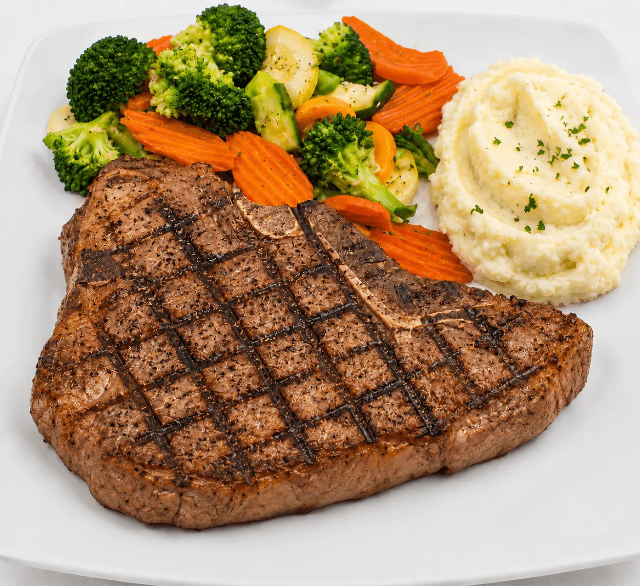 T-Bone Steak with seasonal vegetables and mashed potatoes